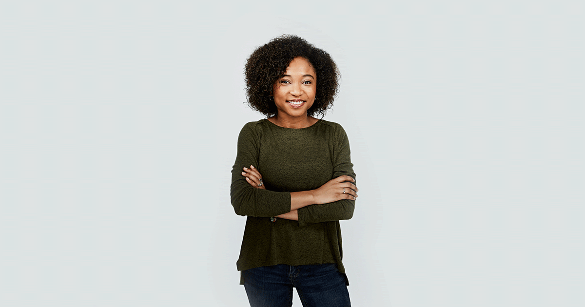 Image of a woman relaxing and smiling with her arms crossed